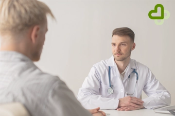 Мужчина сидит на приеме у врача